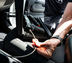 Portable gun safe with firearm and cable lock on car seat