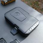 Compact biometric safe with textured surface and keypad on outdoor table