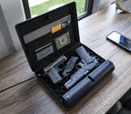 Open biometric gun safe on desk with two handguns, cards, and cash organized inside.