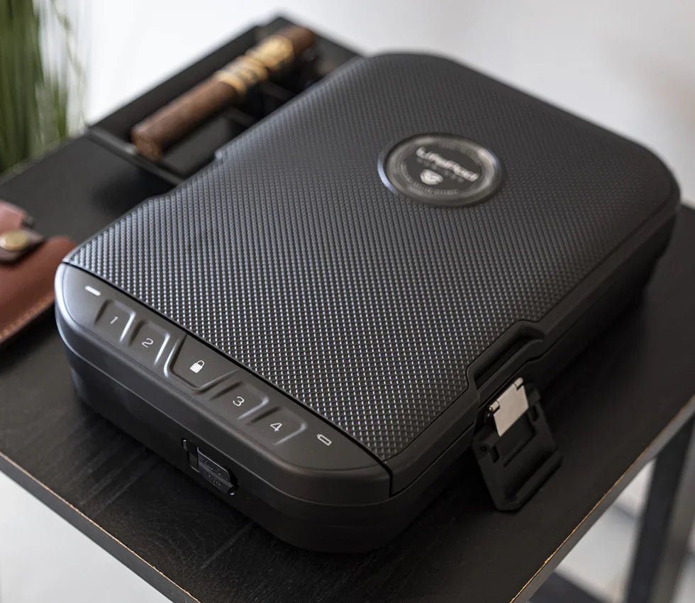 Textured biometric safe with keypad and lock, placed on a black table indoors