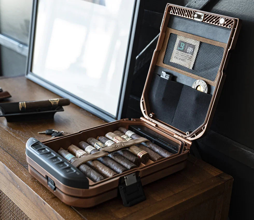 Open portable safe on table storing cigars and accessories in organized compartments.
