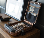Open portable safe on table storing cigars and accessories in organized compartments.