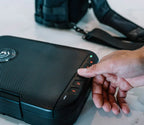 Hand entering code on keypad of compact portable biometric safe on countertop