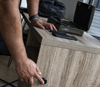 Person activating hidden drawer in wood desk near portable biometric safe and keys