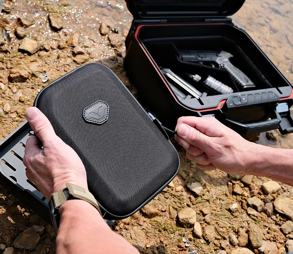Portable lockbox being secured outdoors with open safe containing accessories