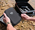 Portable lockbox being secured outdoors with open safe containing accessories