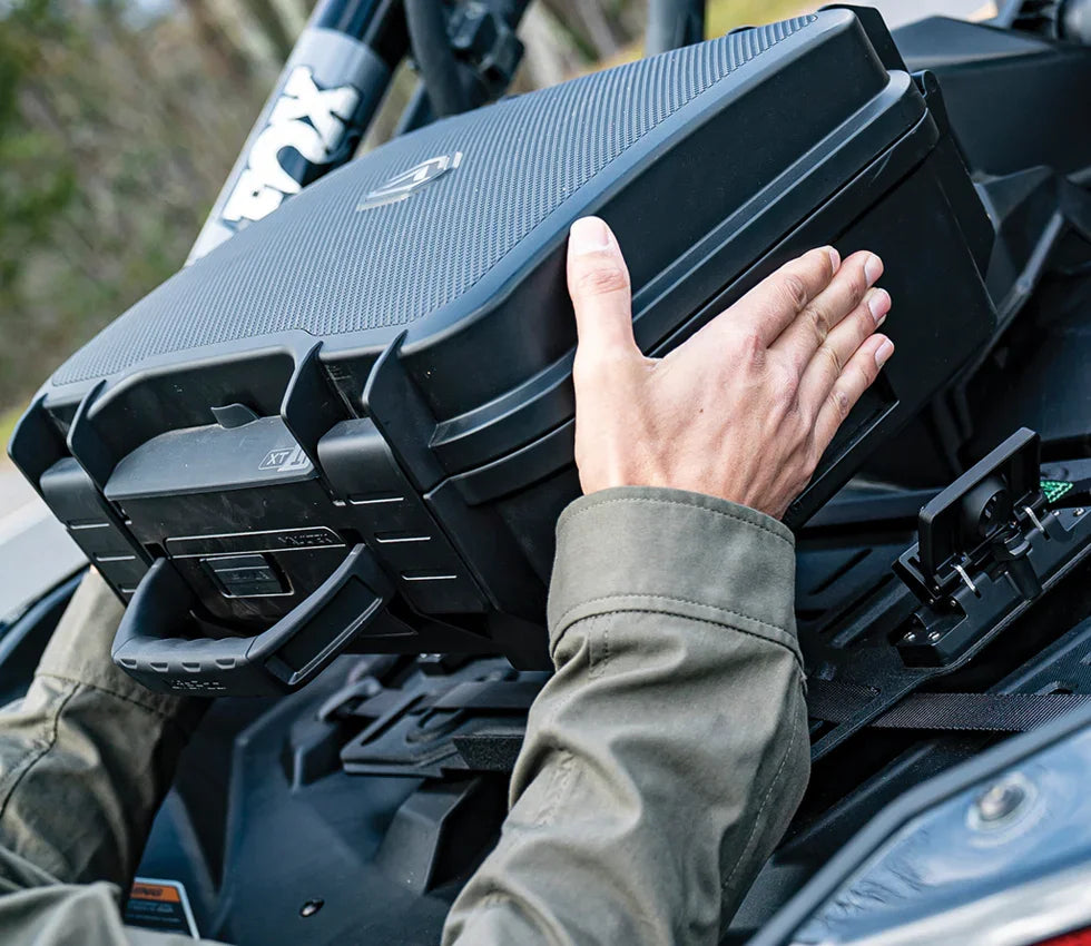 Person installing a rugged portable safe with handle in a vehicle, outdoor setting