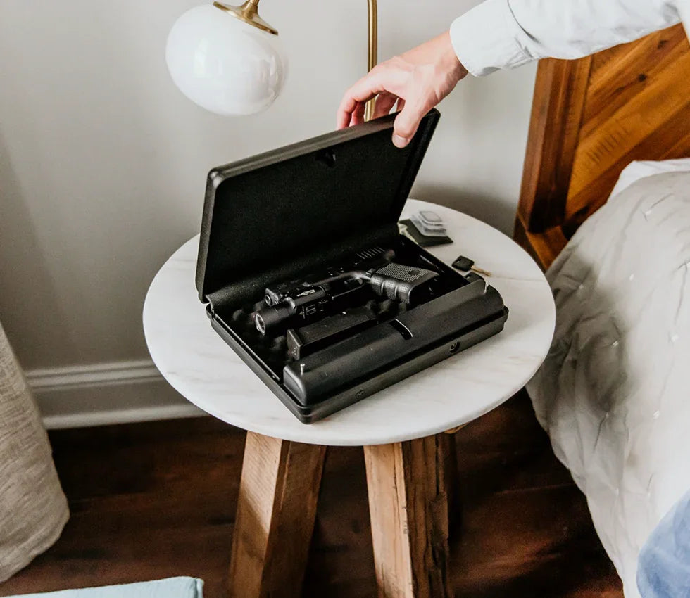 Hand opening biometric safe with firearm inside on bedroom nightstand