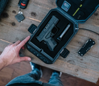 Biometric gun safe with foam interior holding a handgun on a wooden table