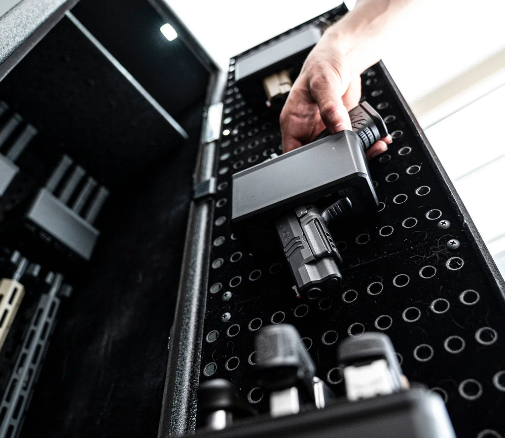 Hand placing handgun in modular storage slot inside a secure home safe